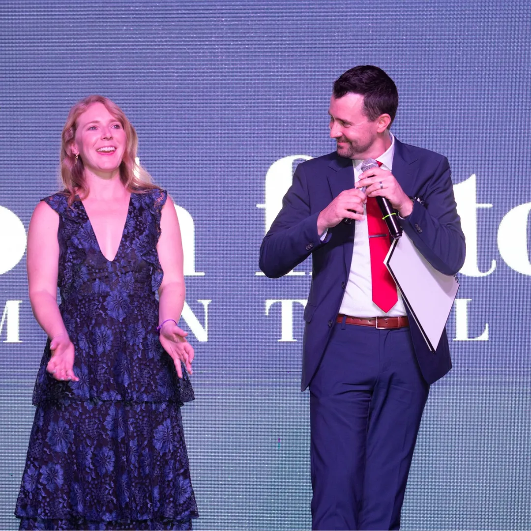 Josh Fletcher performing on stage with a woman in a blue dress