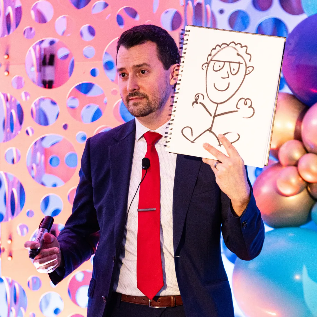 Josh Fletcher performing a mentalist act holding a drawing on stage