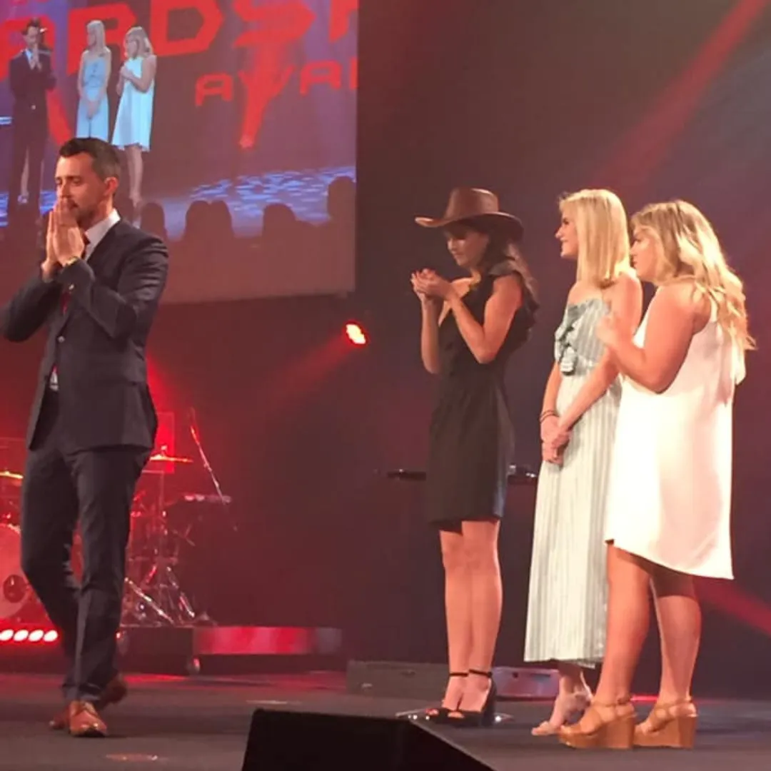 Josh Fletcher performing on stage with three women