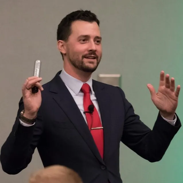 Josh Fletcher speaking at an event with microphone in hand